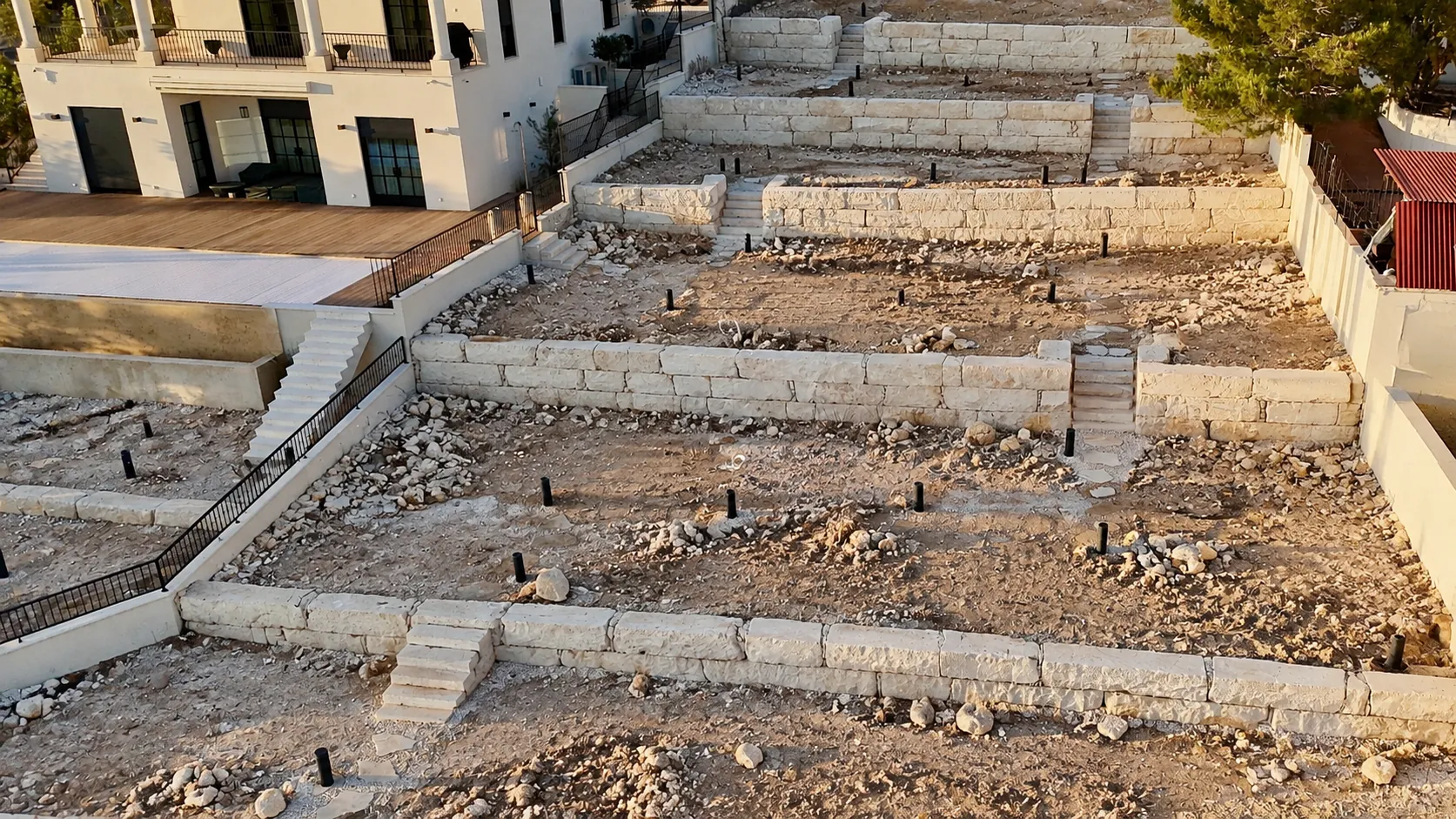 Before: the same Paphos terraces during landscape construction, new stone walls over bare soil and rocks