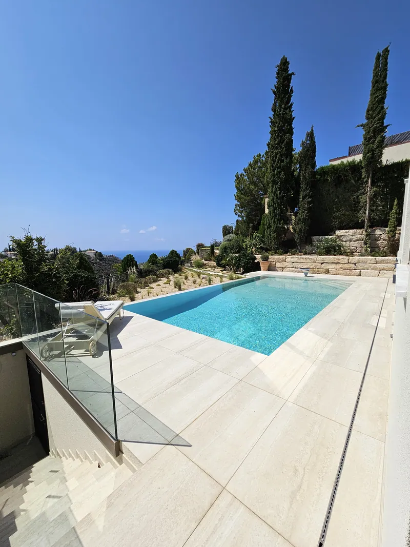 The pool terrace below cypresses and the planted slope
