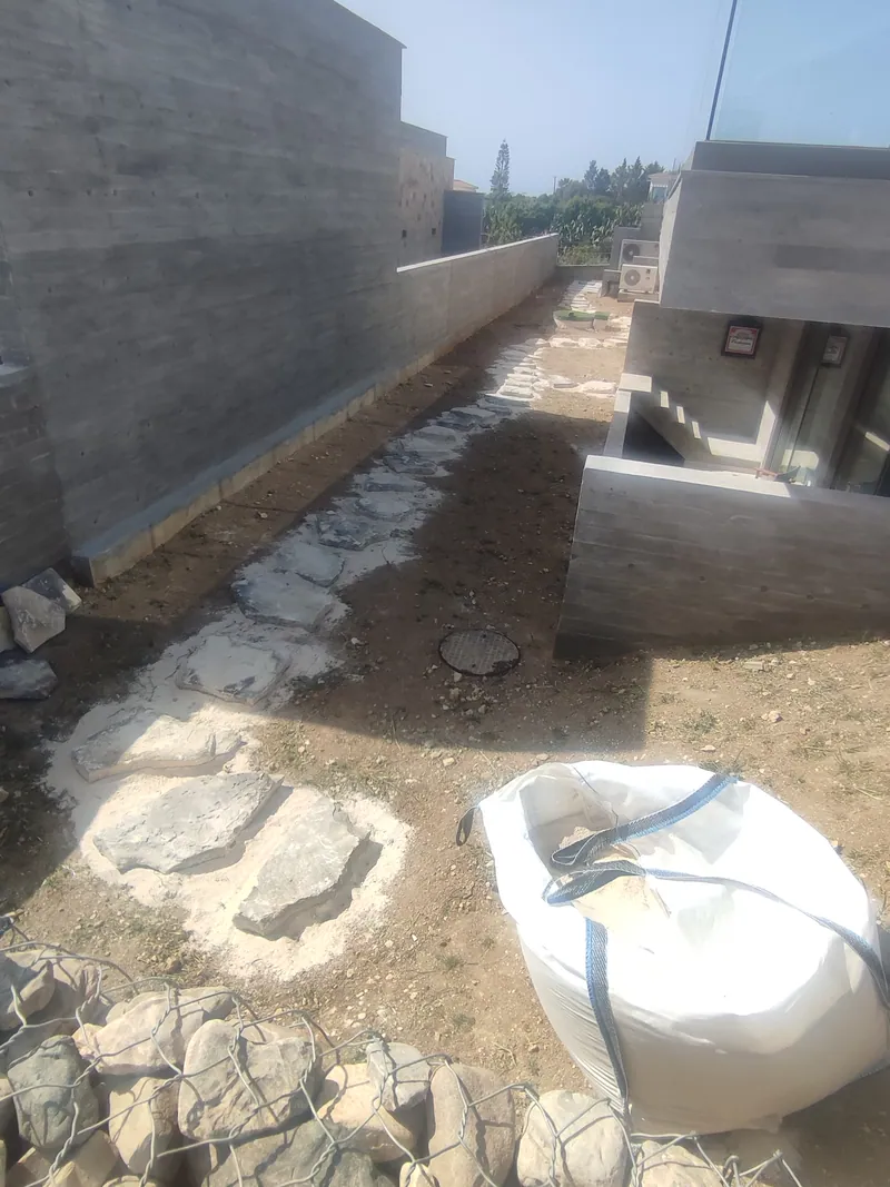 Before: the narrow passage of bare earth, its stepping stones just laid