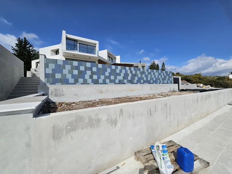 Before: the empty bed along the street below the mosaic-tiled pool wall